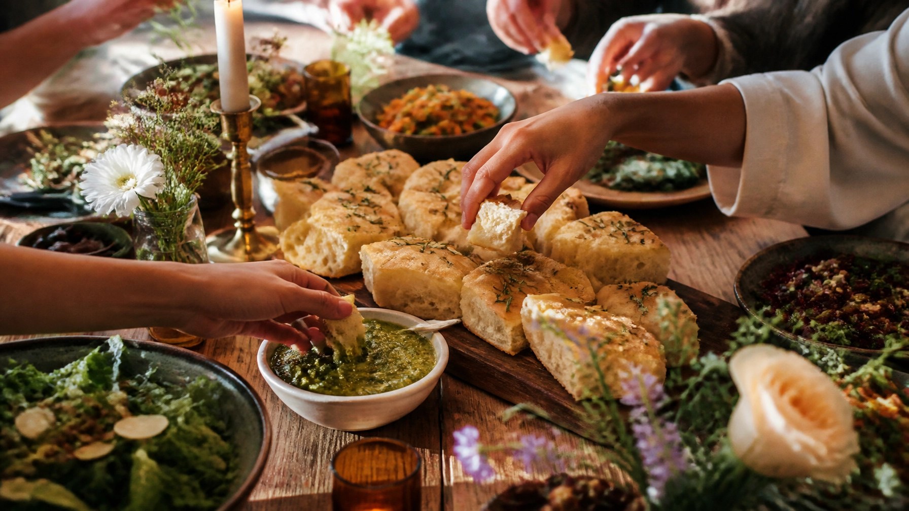 Shared vegan table with rosemary focaccia and nettle pesto ready for guests